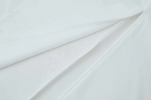 Gros plan sur la texture du tissu blanc avec des coutures soignées sur le col montant