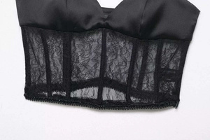Detailansicht eines schwarzen Satin-Korsett-Tops mit floraler Spitze und Fischgräten-Struktur