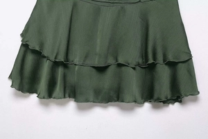 Detail shot of dark green mini skirt showing layered chiffon fabric and pleated texture