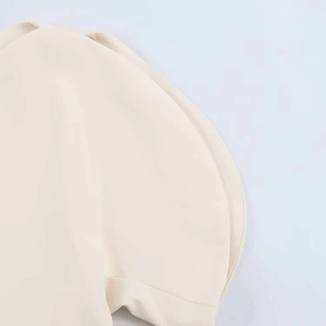 Détail d'une manche bouffante sur un chemisier crème à épaules dénudées avec double couture