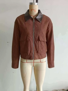 Detail view of brown corduroy jacket featuring a faux leather collar and large flap pockets
