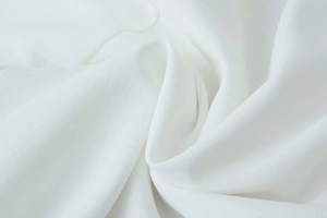 Gros plan sur un tissu mousseline blanc pur avec texture douce et drapé élégant