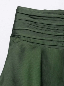 Detail of dark green high-waisted mini skirt with layered pleats and vertical texture