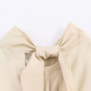 Close-up detail of khaki stand collar dress featuring a back bow tie and neck cutout