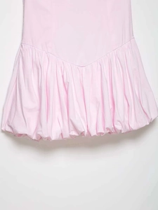 Dettaglio di abito rosa chiaro con orlo a palloncino e vita bassa arricciata in popeline