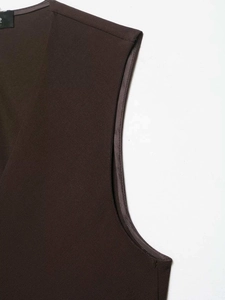 Detailed view of the precise tailoring on the shoulder and armhole of a dark brown vest