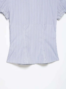 Detail of blue and white vertical striped shirt showing back waist seams and sleeve texture