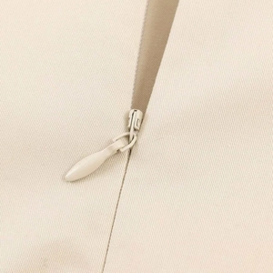 Close-up of the hidden zipper and fine beige fabric texture on the summer dress
