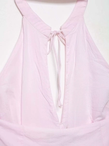 Dettaglio dell'abito all'americana rosa in cotone con scollo a V e lacci decorativi