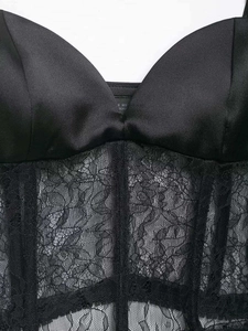 Detailansicht eines schwarzen Korsett-Tops aus Satin und Spitze mit vertikalen Stäbchen