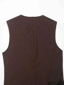 Detailed view of dark brown sleeveless top with asymmetric black lace hem trim
