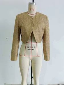 Detail of golden sequined tweed short jacket with metallic texture and round neck