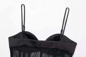 Nahaufnahme der schwarzen Satin-Camisole mit Spitzenbesatz und verstellbaren Trägern