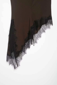Close-up of asymmetrical hem with delicate black eyelash lace on a dark brown top
