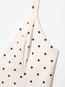 Detailed macro view of the cream polka dot dress fabric with thin shoulder strap