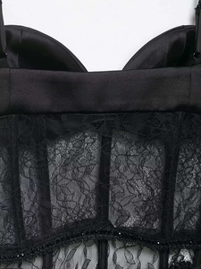 Detailansicht eines schwarzen Satin-Korsett-Tops mit Spitze und eingearbeiteten Formstäben