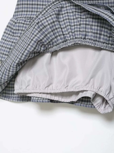 Detail of grey plain fabric safety inner lining with elastic shirred hem for plaid skirt