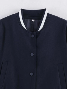 Detail of navy blue baseball jacket with ribbed striped collar and silver snap buttons