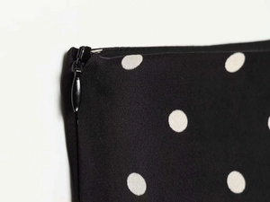 Detail of a black and white polka dot skirt featuring a high-quality invisible zipper