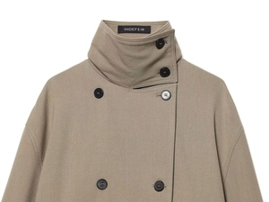Close-up of khaki double-breasted trench coat with high collar and INDEFEIR neck label