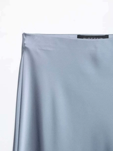 Detail shot of dusty blue satin midi skirt waistline with high-shine silk fabric texture