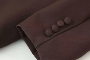 Detail of dark brown blazer cuff featuring four elegant self-covered matching buttons