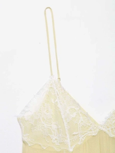 Detail of light yellow camisole featuring intricate white floral lace and eyelash trim
