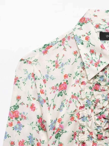 Detailed close-up of floral print shirt with delicate ruffled layers and sharp collar
