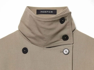 Detail of khaki trench coat collar with branded label and premium double-breasted buttons