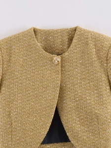 Detail of golden tweed jacket with sequins, round neck, and decorative gold button