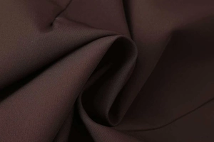 Detailed macro view of dark brown suit fabric texture with soft drape and matte finish