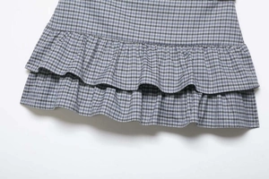 Detail view of double-layer ruffles and fine plaid pattern on blue and white summer skirt