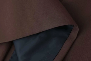Detail of coffee brown fabric and navy blue lining on this slim fit blazer dress