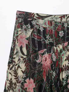 Détail d'une jupe fleurie à taille haute avec fils argentés et motifs de roses vintage