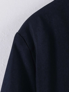 Detailed close-up showing the precise stitching on the shoulder of this navy knit jacket