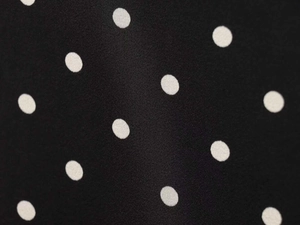 Detailed macro view showing the texture of black and white polka dot chiffon fabric