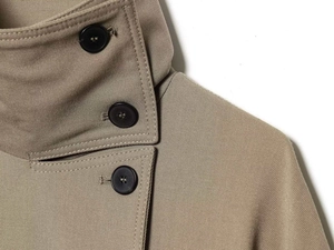 Detailed macro view of khaki twill fabric texture and brown buttons on double-breasted coat