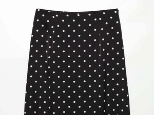 Detail view of black polka dot midi skirt with seamless waist and invisible side zipper