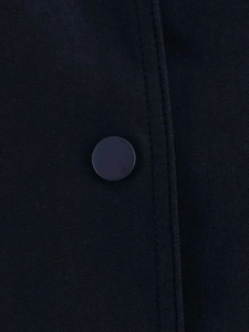 Detailed macro view of navy blue twill jacket fabric with matte button and neat stitching