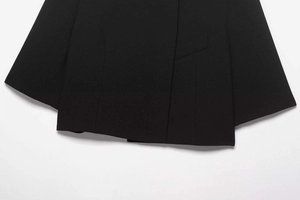 Detail shot of the flat hemline and precision jetted pocket on a black blazer jacket