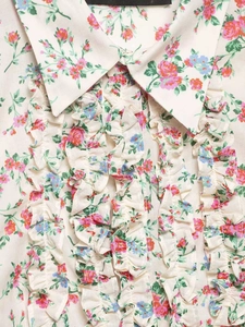 Detail of floral women's shirt featuring layered ruffles and delicate flower patterns