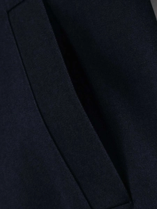 Macro shot of dark navy twill fabric with precision stitching on a women's jacket