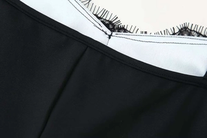 Detailweergave van zwart kant en wit satijnen stiksel op een modieuze zomerjurk