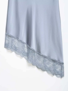Detailed view of asymmetric hem with delicate lace trim on light blue satin skirt