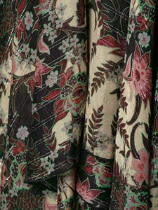 Détail du tissu floral boho avec motifs rouges et fils métalliques argentés en Lurex