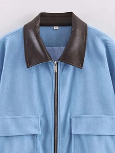 Detail of light blue corduroy jacket with dark brown faux leather collar and silver zipper