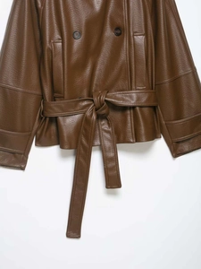 Detail of dark brown leather jacket featuring double-breasted buttons and waist tie belt