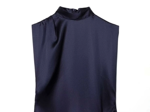Detail of navy blue sleeveless satin top with mock neck and elegant shoulder pleat details