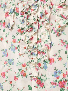 Detail showing vintage floral print and layered ruffles with small buttons on the shirt