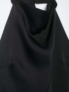 Détail d'une élégante robe en satin noir avec décolleté bénitier et col licou